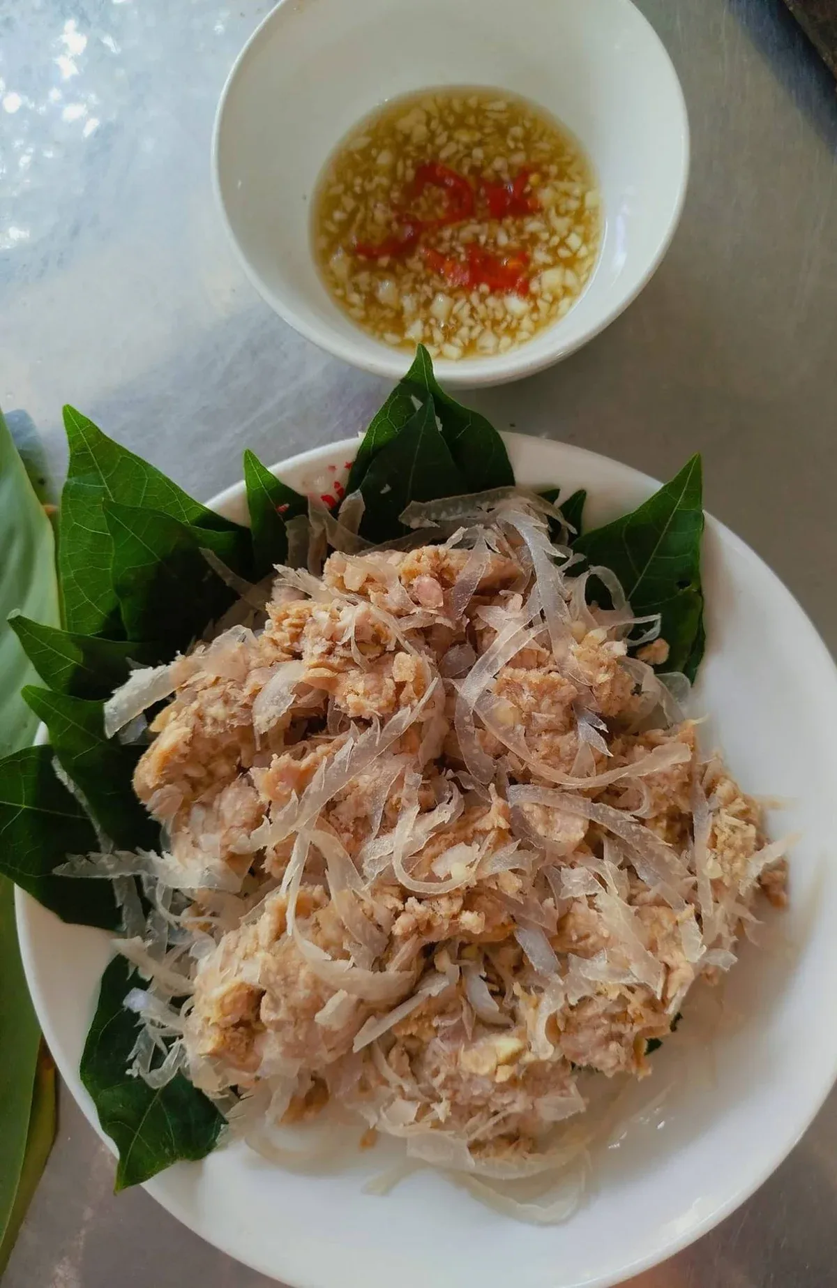 Đĩa nem nắm Nam Định lót lá xanh, bên cạnh bát nước chấm có tỏi và ớt