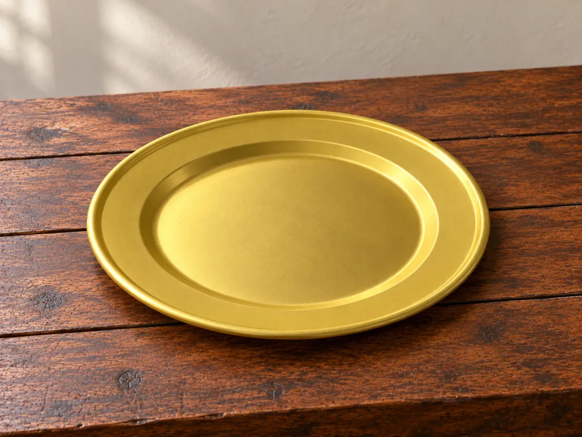 Mâm nhôm anod vàng 32cm còn trống đặt trên bàn gỗ