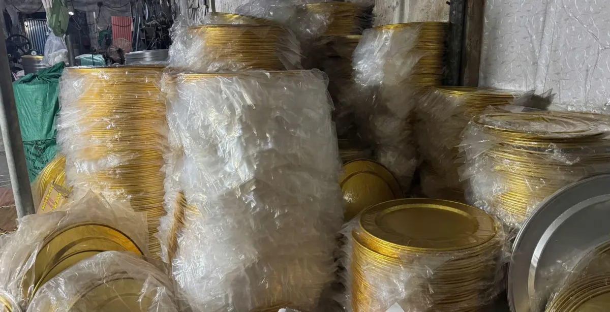 Hàng nghìn chiếc mâm nhôm anod vàng xếp chồng, bọc nilon trong kho xưởng Ecocook, cạnh vài chồng mâm nhôm trắng