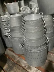 Nhiều chồng nồi nhôm gò nhiều cỡ xếp trong kho