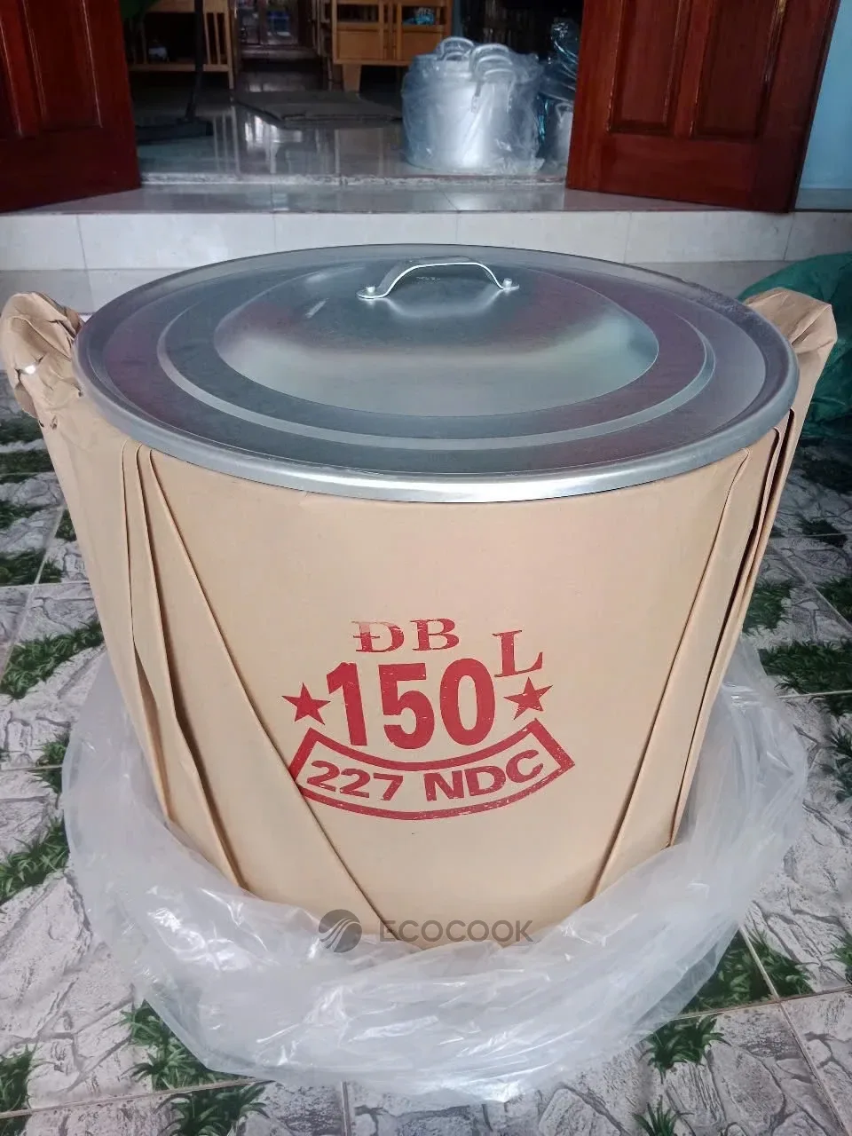 Nồi luộc bánh chưng nhôm 150 lít bọc giấy kraft in dung tích, đặt trên nền nhà, nắp nồi để lộ phía trên